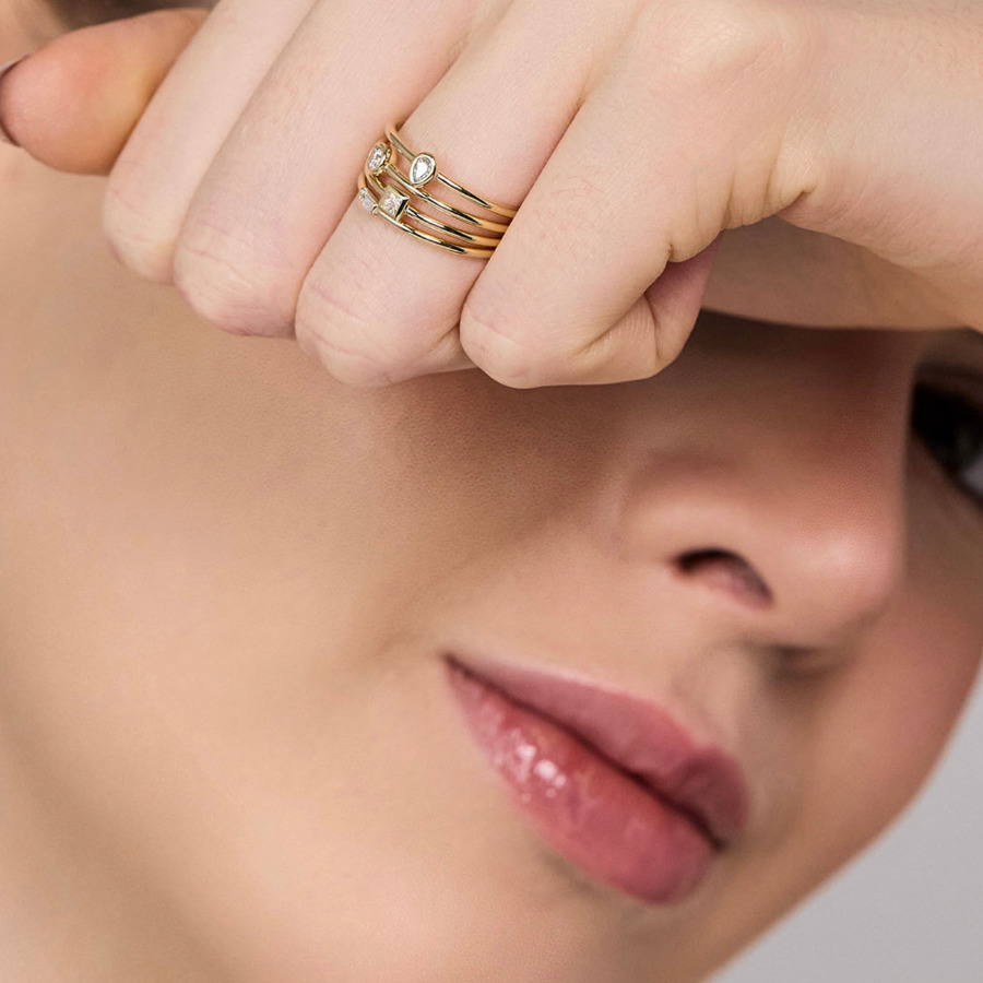 Stackable Rings da Stella Diamonds: mão usando uma composição de anéis em Ouro Amarelo 18k com Diamantes.
